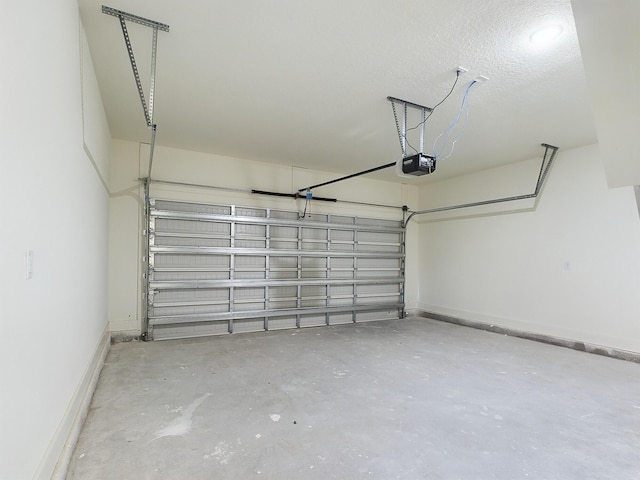 garage with a garage door opener and baseboards