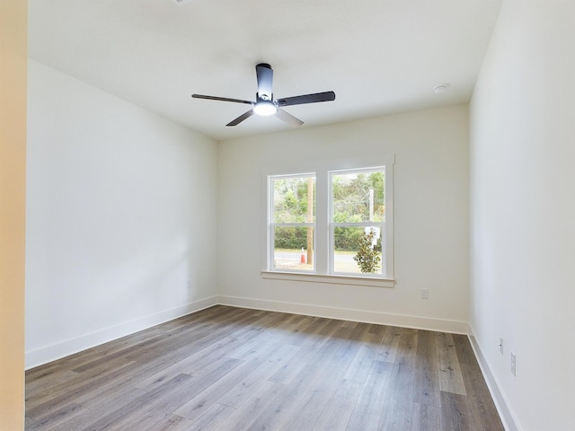 empty room featuring ceiling fan, wood finished floors, and baseboards