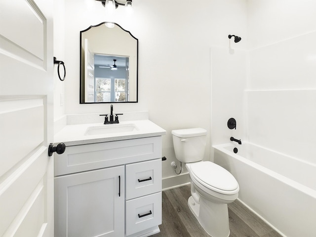 full bath featuring baseboards, toilet, shower / tub combination, wood finished floors, and vanity