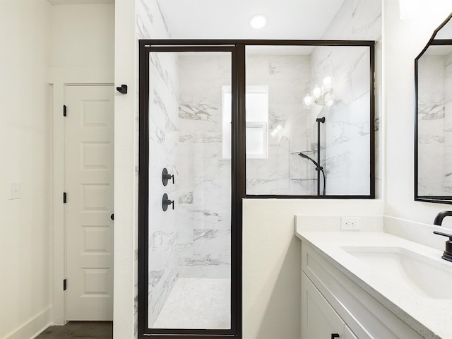 bathroom featuring a marble finish shower and vanity