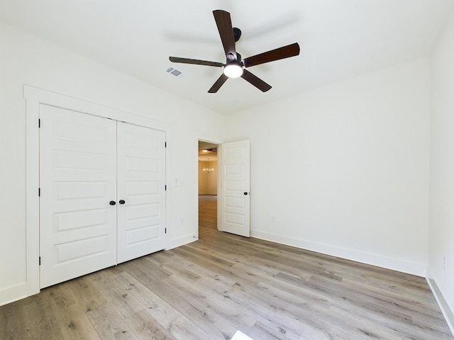 unfurnished bedroom featuring visible vents, a closet, light wood-style flooring, and baseboards