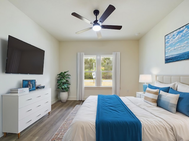 bedroom featuring wood finished floors, a ceiling fan, and baseboards