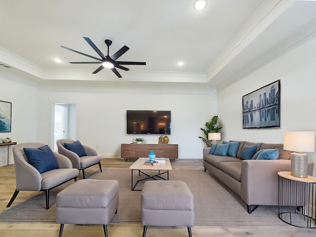 living room with ornamental molding, a tray ceiling, recessed lighting, and wood finished floors