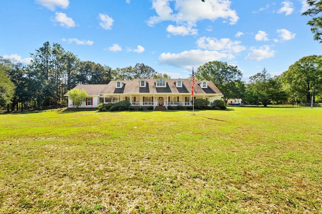 new england style home featuring covered porch and a front lawn