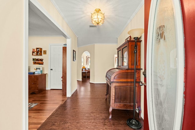 foyer with crown molding, dark wood-type flooring, and a textured ceiling