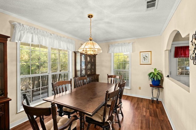 dining area with ornamental molding, dark hardwood / wood-style floors, and a textured ceiling