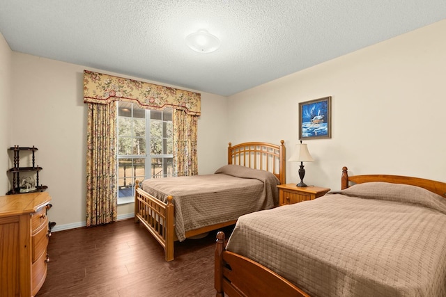 bedroom with dark hardwood / wood-style floors and a textured ceiling