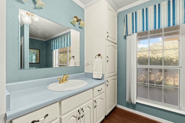 bathroom with hardwood / wood-style flooring, a textured ceiling, vanity, and ornamental molding