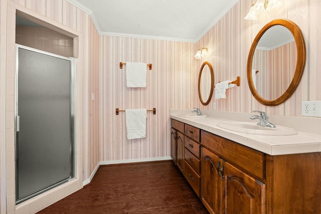 bathroom with vanity, walk in shower, crown molding, and hardwood / wood-style floors