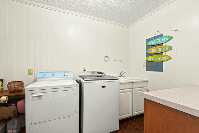 washroom with a textured ceiling, cabinets, sink, independent washer and dryer, and crown molding