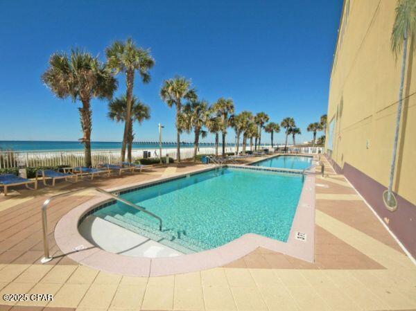 view of pool featuring a patio area and a water view