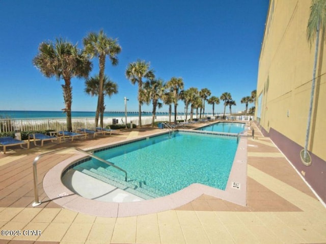 view of pool with a patio and a water view