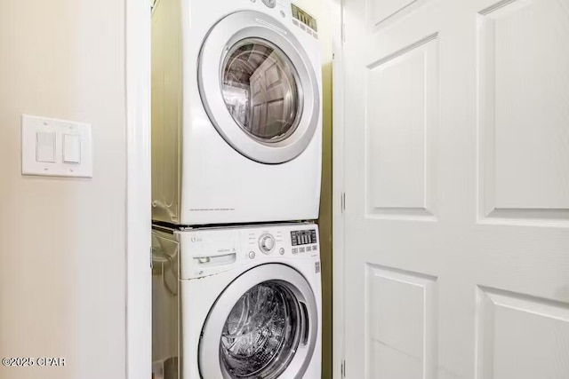 laundry area featuring stacked washer / drying machine