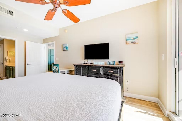 bedroom featuring connected bathroom, ceiling fan, and light wood-type flooring