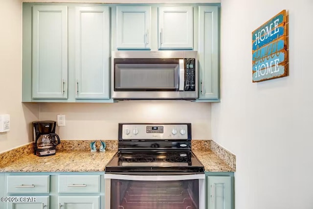 kitchen featuring stainless steel appliances and light stone countertops