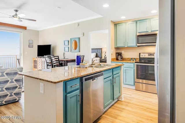 kitchen featuring stainless steel appliances, sink, light hardwood / wood-style flooring, and an island with sink