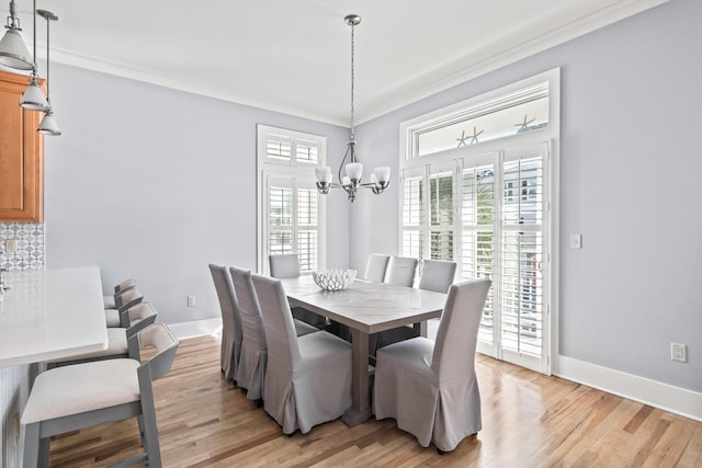 dining room featuring light hardwood / wood-style floors, crown molding, and a chandelier