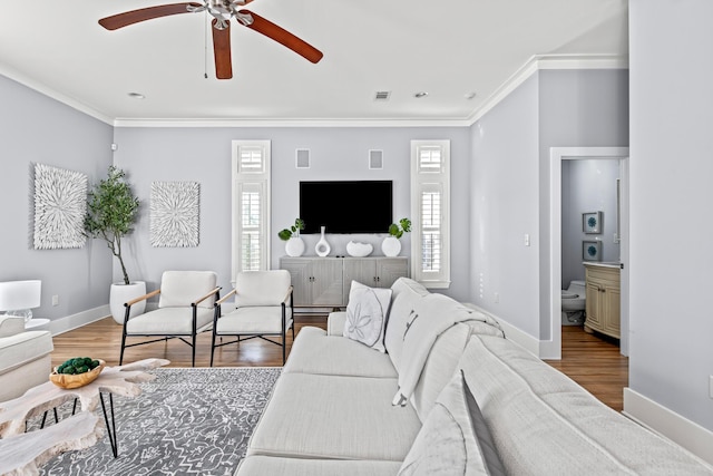 living room with ornamental molding, ceiling fan, a wealth of natural light, and hardwood / wood-style flooring