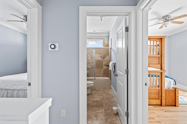 bathroom featuring ornamental molding, ceiling fan, toilet, and combined bath / shower with glass door