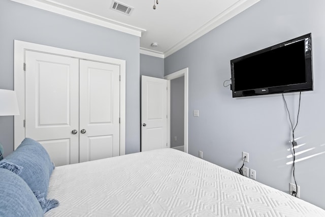 bedroom with ornamental molding and a closet