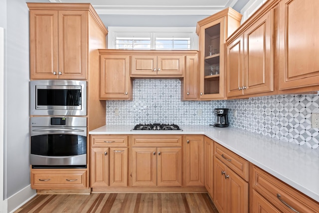 kitchen featuring decorative backsplash, light hardwood / wood-style flooring, and appliances with stainless steel finishes