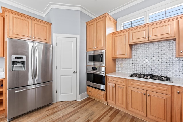 kitchen with ornamental molding, light wood-type flooring, decorative backsplash, light brown cabinetry, and appliances with stainless steel finishes