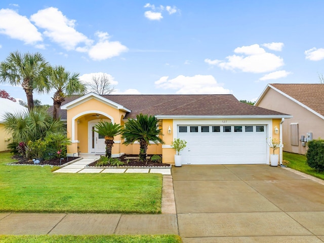 view of front of property featuring a front yard and a garage