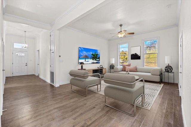 living room with ceiling fan with notable chandelier, wood-type flooring, and crown molding