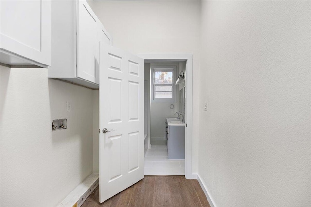 washroom with dark wood-type flooring, sink, and hookup for a washing machine