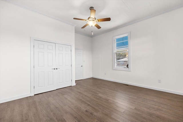 unfurnished bedroom with ceiling fan, dark hardwood / wood-style floors, a closet, and crown molding