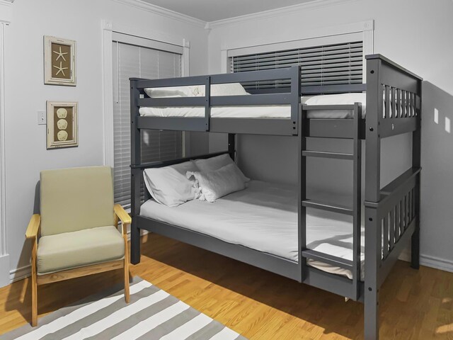 bedroom featuring hardwood / wood-style floors and crown molding