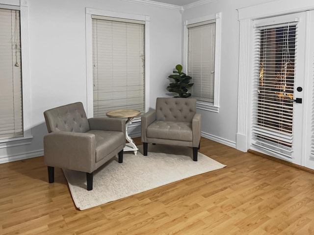 living area with ornamental molding and light wood-type flooring