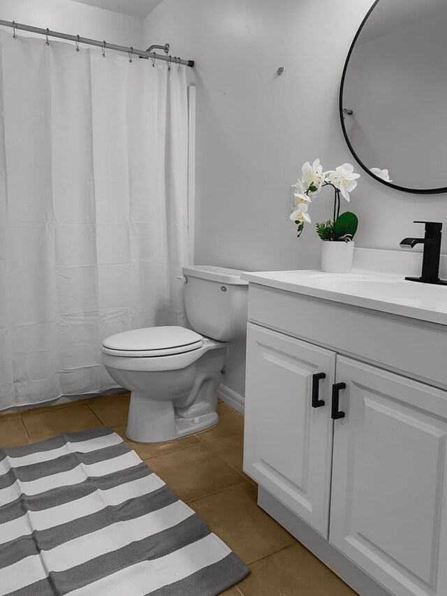 bathroom featuring tile patterned flooring, vanity, and toilet