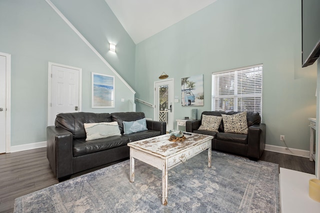 living room with dark hardwood / wood-style flooring and high vaulted ceiling