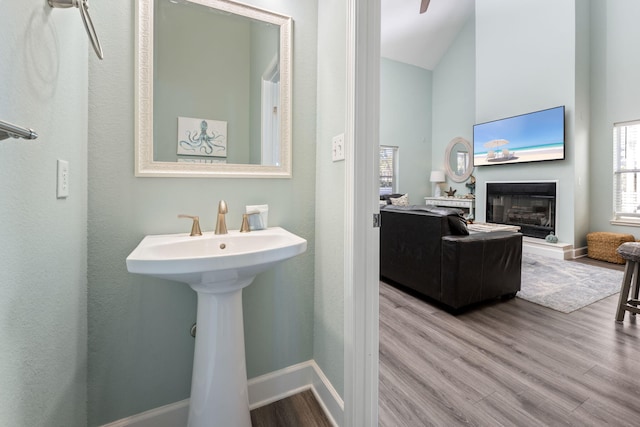 bathroom featuring hardwood / wood-style flooring, a towering ceiling, and sink