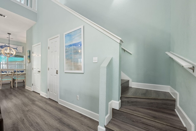 stairway featuring hardwood / wood-style flooring and a chandelier