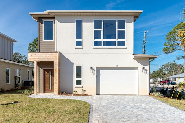 modern home with a garage, central air condition unit, and a front lawn