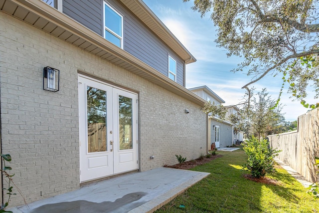 property entrance with a lawn, french doors, and a patio area