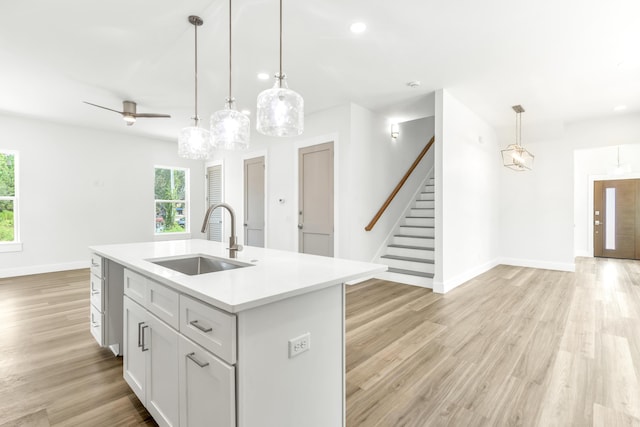 kitchen with sink, pendant lighting, a center island with sink, and ceiling fan