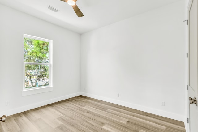 empty room featuring ceiling fan, a healthy amount of sunlight, and light hardwood / wood-style flooring