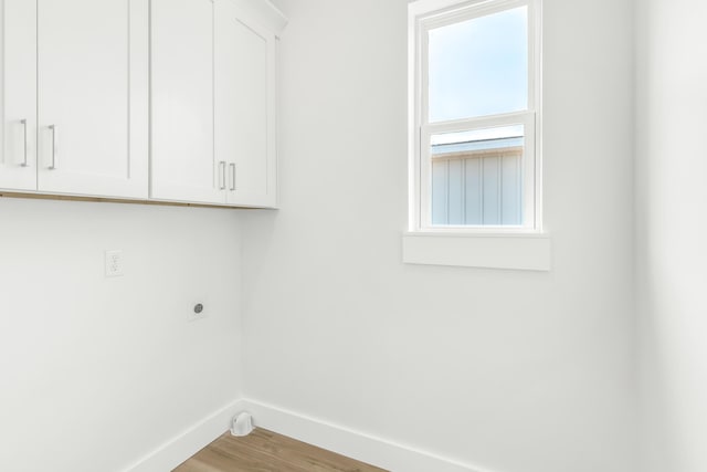 laundry room featuring cabinets, hookup for an electric dryer, and wood-type flooring