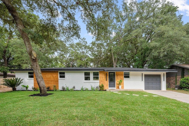 ranch-style home featuring a garage and a front lawn