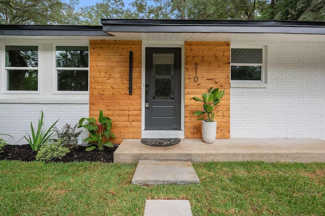 doorway to property with a lawn