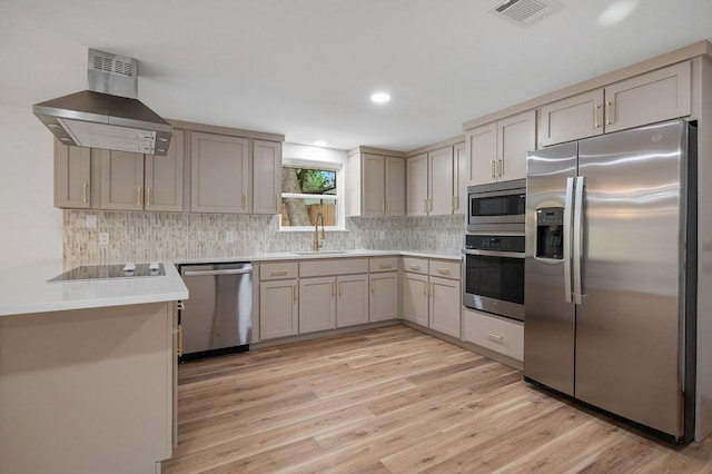 kitchen with stainless steel appliances, light wood-type flooring, island exhaust hood, and sink