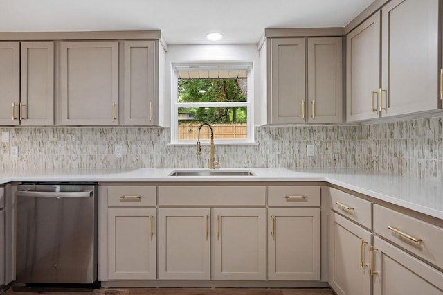 kitchen featuring decorative backsplash, stainless steel dishwasher, gray cabinetry, and sink