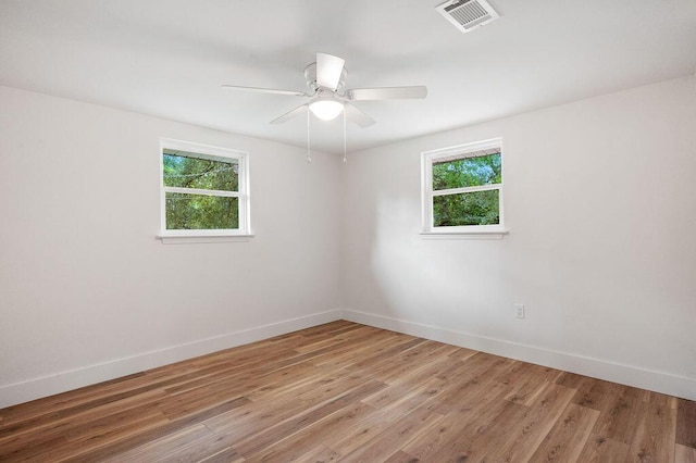 empty room with ceiling fan and light hardwood / wood-style flooring