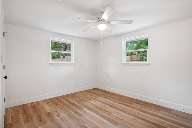 empty room featuring ceiling fan, light hardwood / wood-style floors, and a wealth of natural light