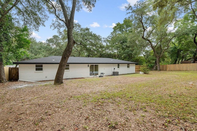 back of property featuring cooling unit and a lawn