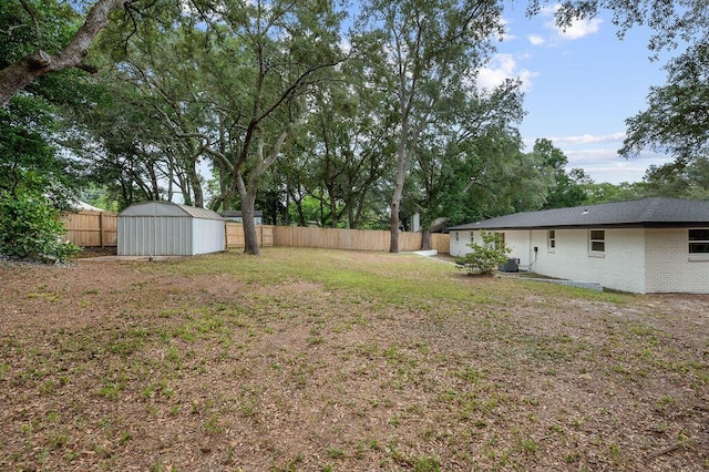 view of yard with central air condition unit and a storage shed