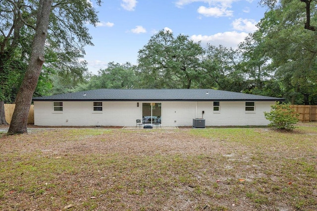 rear view of house featuring central air condition unit, a yard, and a patio area